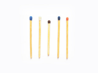 Wooden matches with heads of different colors. Five match sticks isolated on white background, close-up. Berthollet salt, sulfur