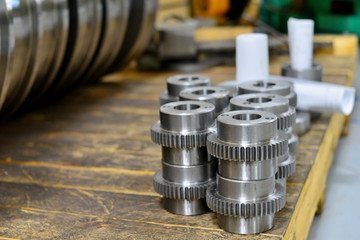 Shaft shaft, gear after machining on the lathe and CNC milling machine lies on a wooden rack in the...