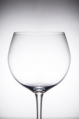 Empty transparent glass for red wine grey gradient background.