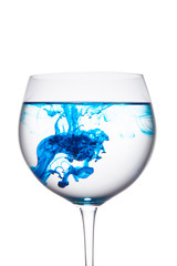 Food coloring diffuse in water inside wine glass area for slogan or advertising text message, isolated white background. © korolkoff