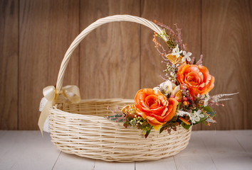 Fototapeta na wymiar Designer basket is decorated with flowers. Wicker basket for celebrating Easter and other holidays.