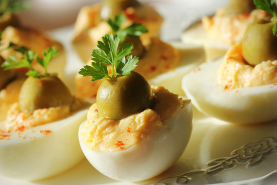 Spicy deviled eggs garnished with green olives and parsley