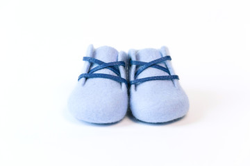 Blue handmade baby shoes made of merino wool on a white background.