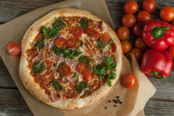 Traditional Italian pizza with tomatoes cheese and pesto on the boards