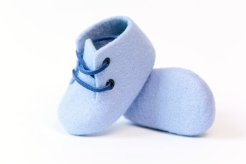 Blue handmade baby shoes made of merino wool on a white background.