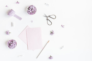 Flowers composition. Paper blank and lilac flowers on white background. Flat lay, top view, copy space