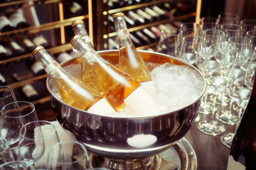 Bottles of orange wine in bowl with ice, toned image