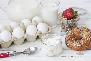 Ricotta, granola, fresh bread and egg - homemade healthy breakfast. Close-up, selective focus, shallow depth of field, white wood background