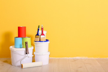 Set with decorator tools and paint on floor near color wall