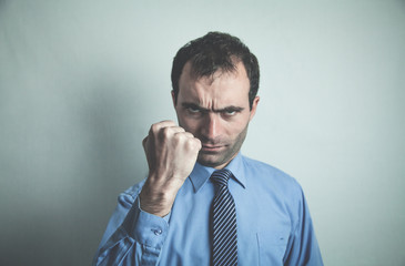 Caucasian angry businessman on gray background.