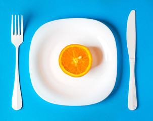 orange fruit in plate concept vegan healthy food gentle blue background
