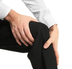 Young man suffering from knee pain on white background