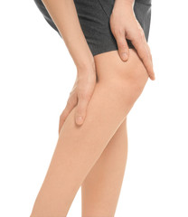 Naklejka premium Young woman suffering from knee pain on white background