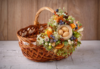 Fototapeta na wymiar Easter basket decorated with flowers and composition of quail eggs