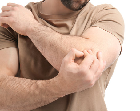 Young man suffering from elbow pain on white background, closeup