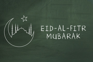 Eid-Al-Fitr mubarak text on green blackboard. Welcoming ramadan.