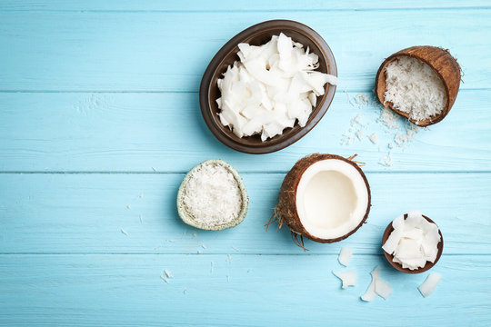 Composition with fresh coconut flakes on color wooden background, top view