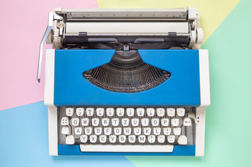 High angle view of retro typewriter against colorful background.