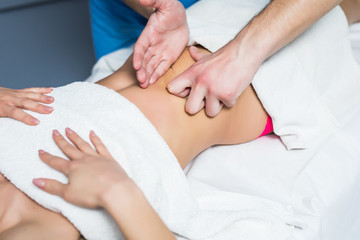 Fototapeta na wymiar Masseur conducts anti-cellulite massage of the woman abdomen