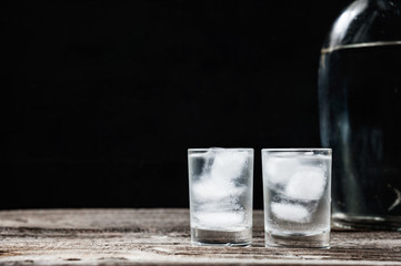 Cold vodka in shot glasses on a black background