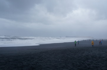 Touristen an schwarzem Strand in Island