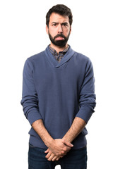 Sad handsome brunette man with beard on white background