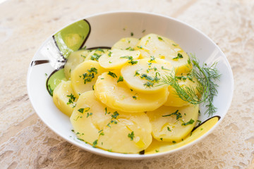 Insalata con fette di patate bollite e condite con olio e prezzemolo