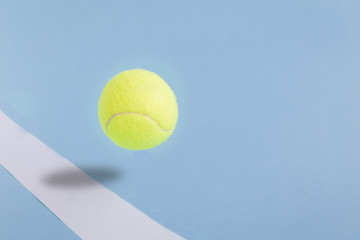 Tennis ball against pastel blue background minimalistic concept. Space for copy.