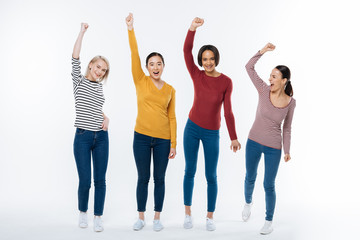 Obraz premium Our achievement. Joyful nice attractive women standing together and saying yes while being happy about their achievement