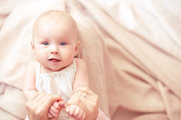 Funny girl lying in bed holding mother hands closeup. Motherhood. Good morning.