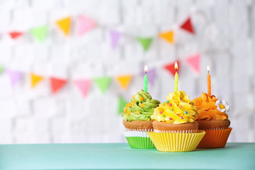 Birthday cupcakes with candles against blurred background