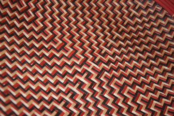 Closeup of seamless red, white and black craft pattern. Closeup of Latin American ethnic vintage handicraft.