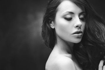 Fototapeta premium Black and white portrait of an attractive young woman. Beautiful model with curly hairstyle