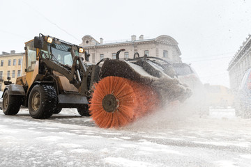 Snowplow truck vehicle removing snow after blizzard and snowstorm. Urgent city street cleaning at daylight. Winter in St. Petersburg