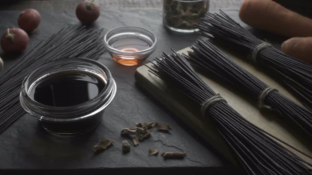 Rice noodles, vinegar and vegetables on the stone. Asian cuisine. Video desaturate