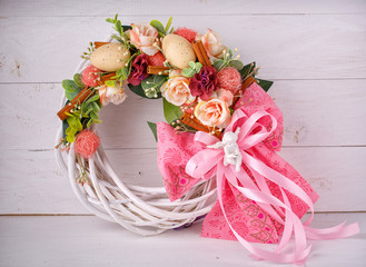 Decorative woven wreath is decorated with flowers and quail eggs. © serkucher