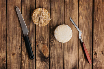 Top View of Crafted Cheese with Knives on a Wooden Surface.