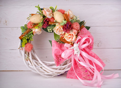 Decorative woven wreath is decorated with flowers and quail eggs.