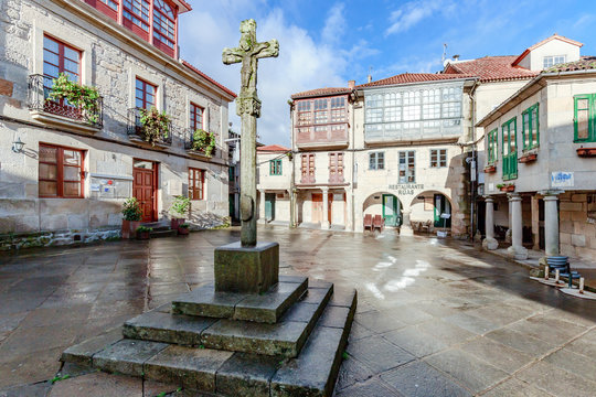 Spanien - Historischer Platz Praza da Lena in Pontevedra in Galicien. Geb&auml;ude mit farbiger Fassade, Holzfenstern, Balkonen und einem Steinkreuz in der Mitte.