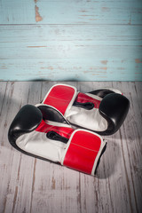 Boxing gloves on blue and white cracked wooden background