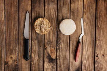 Top View of Crafted Cheese with Knives on a Wooden Surface.