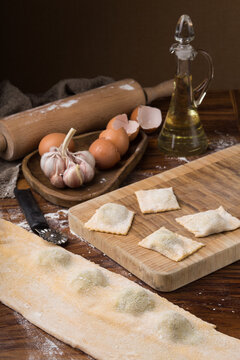 mug flour, eggs, rolling pin, olive oil in a jar on a wooden background, making ravioli