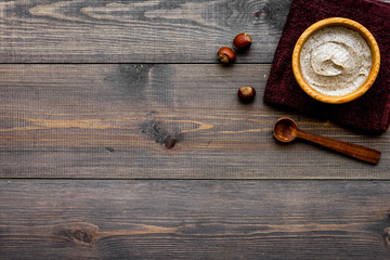 Obraz na płótnie Canvas organic scrub with hazelnut for homemade spa on wooden background top view mockup