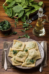 ready ravioli in a plate, spinach, olive oil in a jar