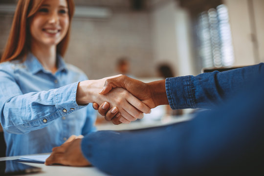 Young woman signing contracts and handshake with a manager