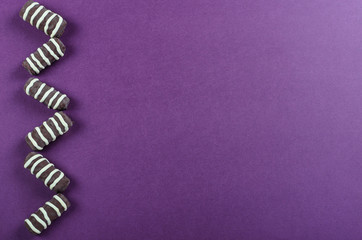 Chocolate candies in the form of chopsticks with white strips are lined in the form of a zigzag on...