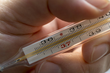 Close Up Image Of Thermometer Showing High Temperature.Human hand holding medicine healthcare thermometer