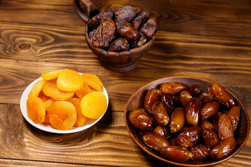 Dried apricots and dates fruit on wooden table