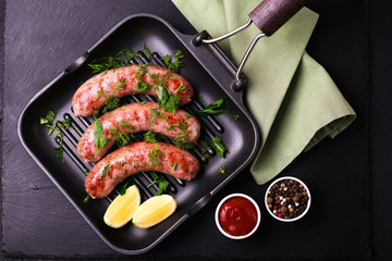 Grilled sausages with lime on iron grill pan