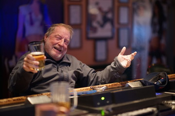 Elderly Bar Patron Having An Alcoholic Drink Smiling